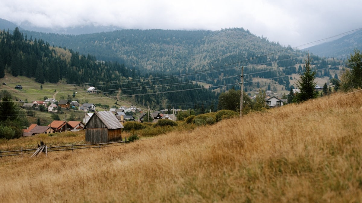 A grassy hill with a small village in the distance